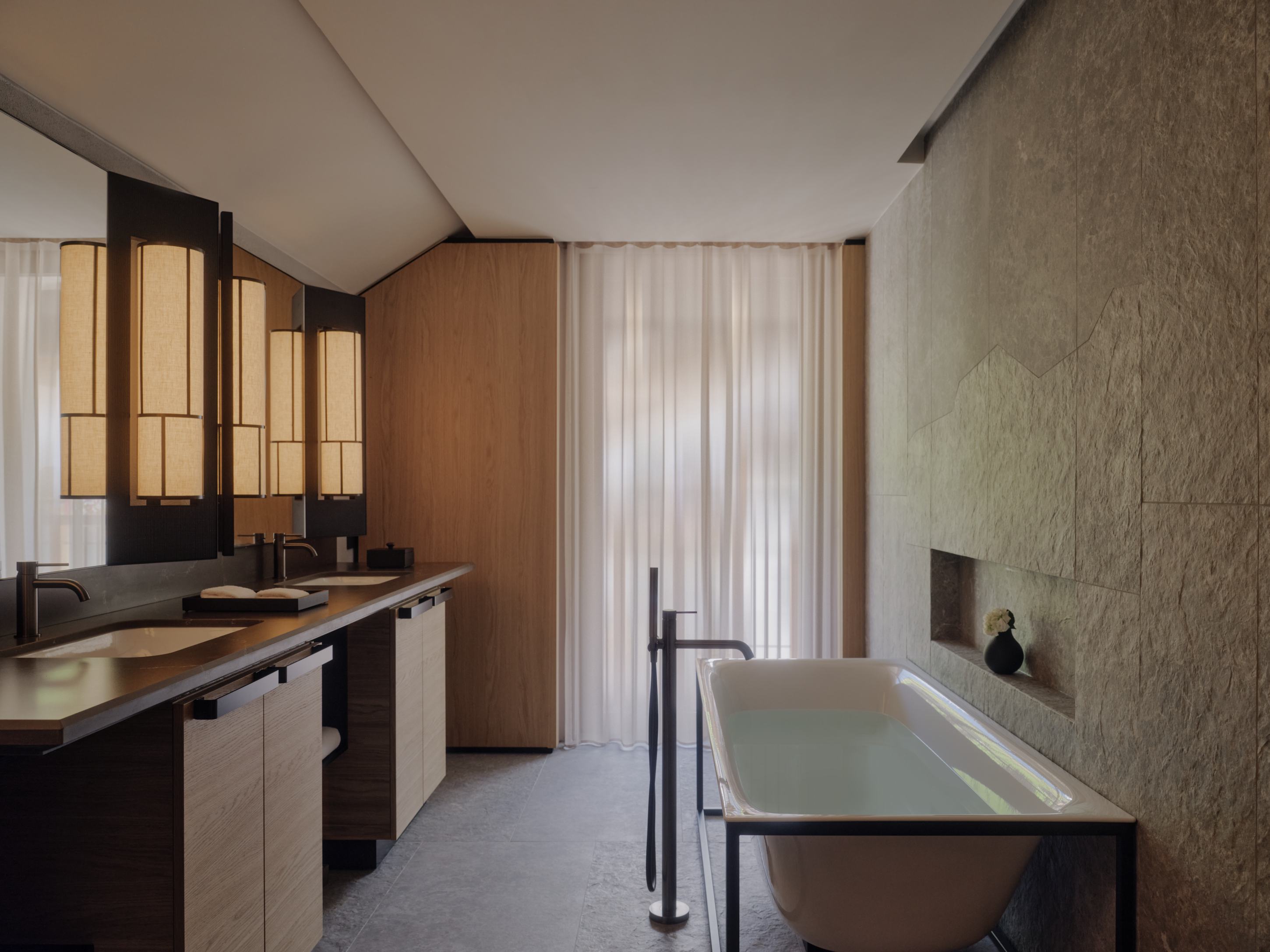 Aman Rosa Alpina Deluxe Room &ndash; Badezimmer mit Badewanne, Waschtisch und warmen Holzoberfl&auml;chen | nova-reisen