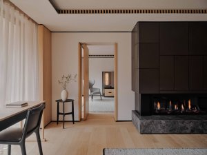 Aman Rosa Alpina Suite – Wohnbereich mit Schreibtisch, Kamin und hellem Interieur