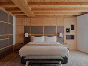 Aman Rosa Alpina Zeno Suite – Schlafzimmer mit Holzdecke, Doppelbett und warmem Design | nova-reisen