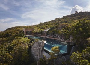 ALT-Text:Amanoi Vietnam Ocean Pool Residence – privater Pool in Hanglage mit Blick über grüne Hügel und Küstenlandschaft | nova-reisen