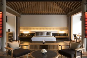 Amanoi Vietnam Pavilion Villa Bedroom – Schlafzimmer mit Kingsize-Bett, Holzinterieur, indirektem Licht und ruhiger Atmosphäre | nova-reisen