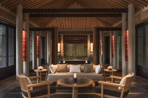 Amanoi Vietnam Pavilion Villa Living Area – Lounge-Bereich mit Sofas, Holzdecke, offenen Türen und Blick ins Grün | nova-reisen