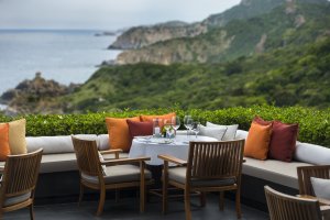 Amanoi Vietnam Main Restaurant Terrace – gedeckte Tische auf der Terrasse mit Blick auf grüne Berge und die Bucht | nova-reisen