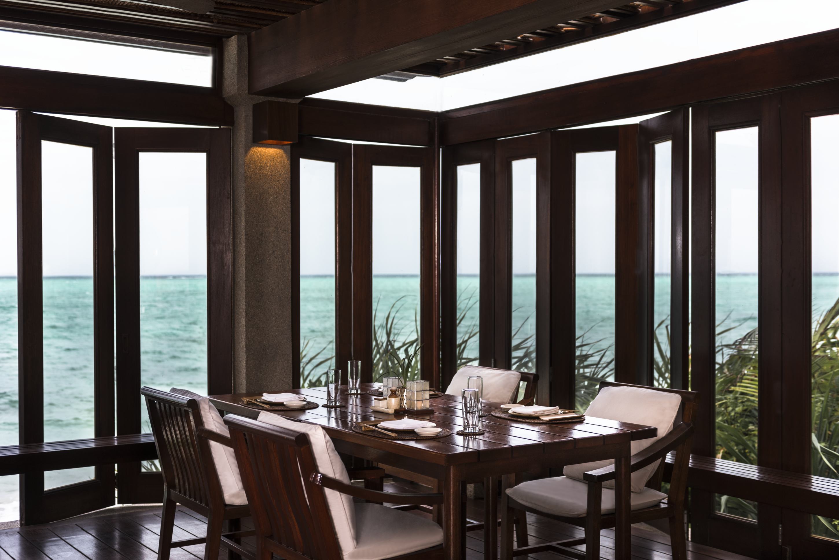 Amanpulo Philippinen Nama Restaurant &ndash; eleganter Dining-Bereich mit gro&szlig;en Fenstern und Meerpanorama | nova-reisen