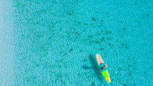 Amanpulo Philippinen Paddleboarding – Stand-up-Paddling auf glasklarem Wasser über hellem Sandboden in der Lagune | nova-reisen