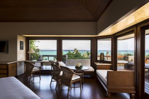Amanpulo Philippinen Deluxe Hillside Casita – Schlafzimmer mit Sitzecke, Holzinterieur und Blick aufs Meer | nova-reisen