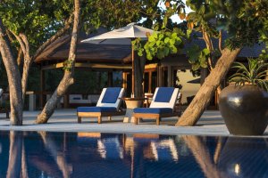 Amanpulo Philippinen Palawan Villa – Pooldeck mit Liegen und tropischer Vegetation an der Four-Bedroom Villa | nova-reisen