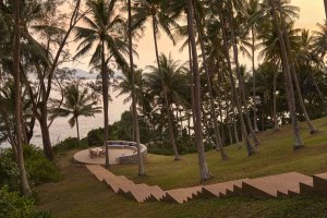 Amanpuri Thailand Outdoor Dining – Stufen und Dining-Bereich im Palmenhain mit Abendstimmung nahe am Meer | nova-reisen
