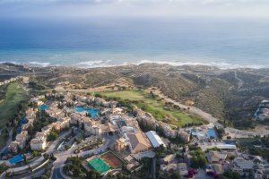 Luxusreise Zypern – Luftaufnahme Aphrodite Hills Golfresort mit Poolanlage, Golfplatz und Küstenpanorama | nova-reisen