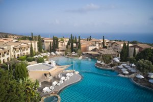 Luxusreise Zypern – Außenpool mit Sonnenliegen und Meerblick im Aphrodite Hills Golfresort auf Zypern | nova-reisen