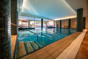 Luxusreise Zypern – stimmungsvoller Indoor-Pool mit Holzdecke und Unterwasserbeleuchtung im Aphrodite Hills Golfresort | nova-reisen
