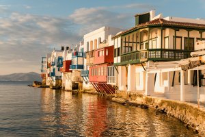 Four Seasons Hotel Mykonos mit Blick auf das charakteristische Dorf mit bunten Häuserfront am Wasser | nova-reisen