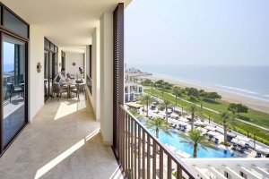 Langgezogene Terrasse der Präsidenten Suite im Mandarin Oriental Muscat mit stilvollen Lounge-Möbeln, direktem Blick auf den glitzernden Infinity-Pool und das Arabische Meer – exklusiver Rückzugsort für Luxus und Ruhe in Oman.