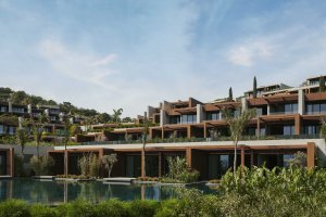 „Moderne Wohngebäude im Maxx Royal Bodrum mit großen Balkonen, Poolanlage und üppiger Begrünung – luxuriöses Resortambiente an der türkischen Riviera.