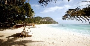 wunderschöner traumstrand unter palmen im north island resort auf den seychellen