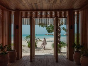 Holzterrasse mit Meerblick: Rahmenblick durch Holzportal auf Lagune/Palmen | Saudi‑Arabien, Nujuma