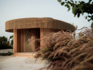 Privates Spa-Haus aus Naturstein mit Holzfassade, eingebettet in grüne Landschaft | Saudi-Arabien, Nujuma