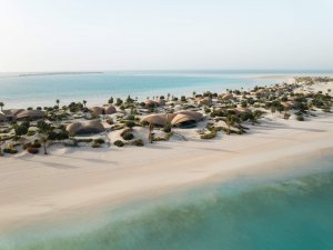 Luftaufnahme von Overwater-Villen und weißem Sandstrand in türkisblauer Lagune | Saudi-Arabien, Nujuma