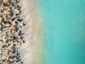 Sandstrand mit türkisfarbenem Meer und Palmen – Nujuma Ritz-Carlton Reserve Saudi-Arabien