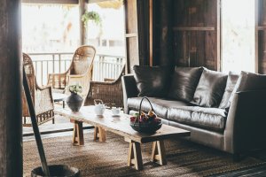 retro stil foto mit alter bar und lounge mit leder couch und obstkorb auf dem tisch die terrassentpr ist offen und alles ist aus viel holz im schönen exklusiven klassischen urigen und altmodischen hotel phun baitang in kambodscha asien 