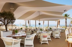 Del Mar Restaurant am Strand des Luxusresort Marbella Puente Romano Beach Resort & Spa Spanien Andalusien mit großen Sonnenschirmen und gemütlichen Sesseln unter Palmen