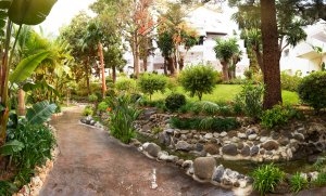 schöne gepflegte Gartenanlage des Luxusresort Marbella Puente Romano Beach Resort & Spa Spanien Andalusien mit vielen Pflanzen und Palmen