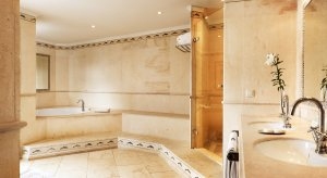 Blick in das helle und luxuriöse Bad der Grand Junior Site im Luxusresort Marbella Puente Romano Beach Resort & Spa Spanien Andalusien mit großer Dusche, Eckwanne und Doppelwaschbecken