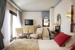 gemütliche Suite mit Sitzecke, TV und großem Bett im Luxusresort Marbella Puente Romano Beach Resort & Spa Spanien Andalusien