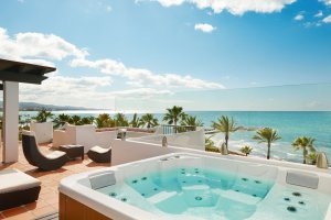 Jacuzzi auf der Terrasse der Suite Real mit Blick auf das strahlend blaue Mittelmeer und die Palmen am Strand des Luxusresort Marbella Puente Romano Beach Resort & Spa Spanien Andalusien