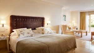 großes gemütliches Bett in der Suite im Luxusresort Marbella Puente Romano Beach Resort & Spa Spanien Andalusien mit Sitzecke und viel Platz auf der eigenen Terrasse
