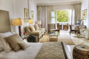 gemütliches und helles Zimmer im Luxusresort Marbella Puente Romano Beach Resort & Spa Spanien Andalusien mit beige Tönen und Blick auf die Terrasse