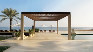 grosser pool mit meerblick und mit palmen im ritz carlton al bustan luxus hotel in muscat oman