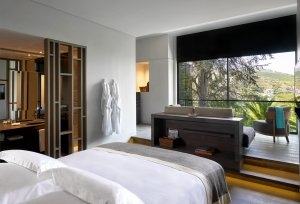Quinta Deluxe Zimmer mit herrlichem Ausblick aus den großen Fenstern vor dem Bett Luxusurlaub im Herrenhaus Portugal Six Senses Douro Valley Portugal