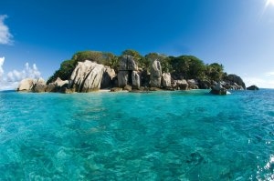 Einsame Insel Coco Island inmitten saphirblauem Meer gelegen zeigt was einen Luxusurlaub im Six Senses Zil Pasyon ausmacht