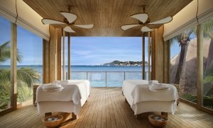 Innenansicht des Spa im Six Senses Zil Pasyon mit Blick auf das saphirblaue Meer und den Palmenstrand