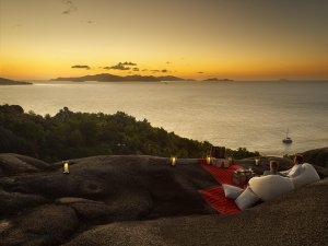 Romantischer Sonnenuntergang auf einem Felsen des Six Senses Zil Pasyon mit gemütlichen Kissen und Luxus-ausblick