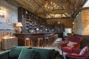 gemütliche klassische bar mit viel holz und großer theke im exklusiven soho farmhouse in england Oxfordshire