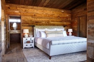 grosses zimmer mit viel holz und einem gemütlichen bett in altmodischen ländlichen country stil mit teppich im exklusiven soho farmhouse in england Oxfordshire